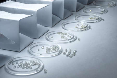 The sorted diamonds are in glass cups. The result of manual sorting of diamonds by weight and...