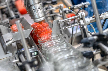 Machine for filling red caviar into glass jars. Filling equipment, food industryの写真素材