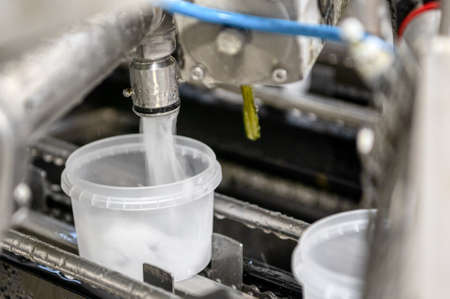 Automatic line for packing seafood. Stacking seaweed and pouring brine into plastic jarsの写真素材