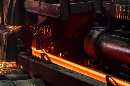 Red-hot metal billet on the roller table of a rolling mill