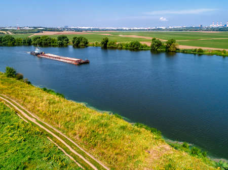 A cargo barge floats on a small riverの写真素材