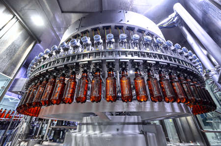 Filling plastic bottles with various drinks on an automatic filling machineの写真素材