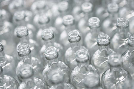 Lines of empty glass bottles for vodka drink in workshopの写真素材