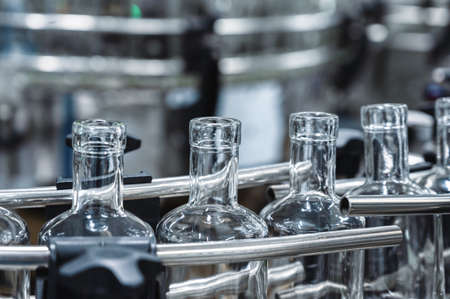 Long row of empty glass bottles for alcohol drinks at plant