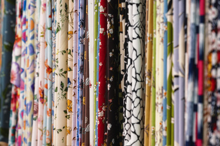 Elegant natural fabrics with floral patterns hang in hallway