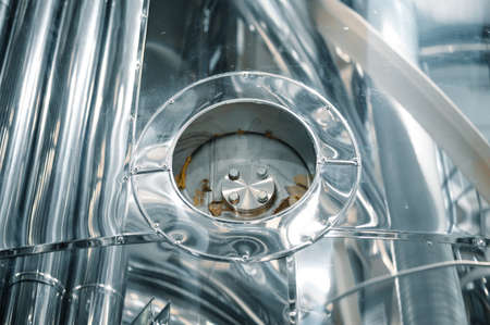 Side hatches with walls of metal tanks for making alcohol drinks in light workshopの写真素材