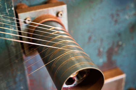 Coil winder with jackshaft and thin copper wire in workshop