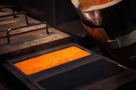 Rectangle graphite casting form full of hot liquid silverの写真素材