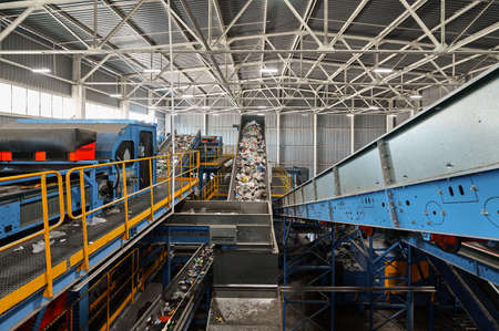 Trash transported by conveyor in recycling plant workshop
