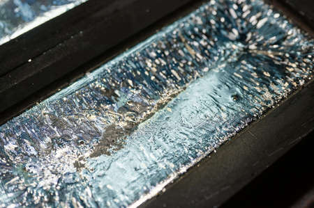 Biscuit of shiny silver cools down in graphite casting form