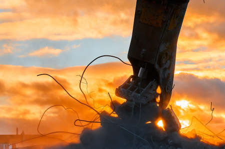 Metal crusher on excavator rigging destroys armored concrete
