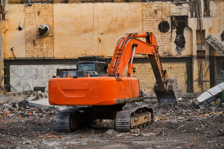 Hydraulic excavator works with garbage at demolition siteの写真素材