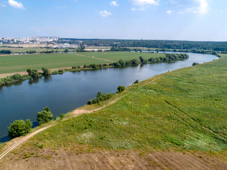 Wide river flowing between fields