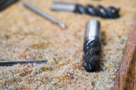 Set of various new drills on sand in container close viewの写真素材