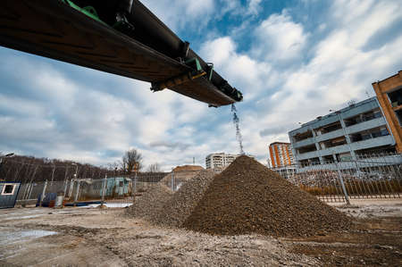 Soil falls from conveyor of crushing and sorting complexの写真素材