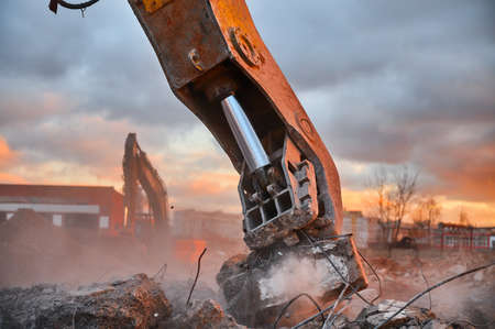 Metal crusher on excavator rigging destroys armored concreteの写真素材