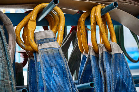 Rigging equipment with textile strops hangs on rack hooksの写真素材