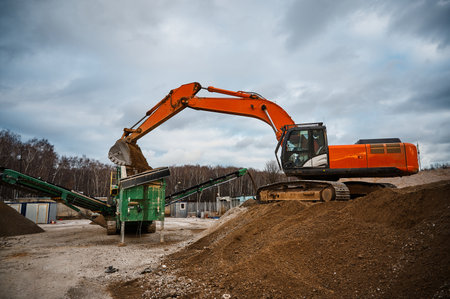 Excavator loads soil in mobile crushing and sorting complex