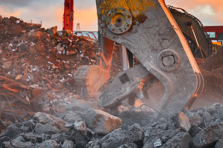 Metal crusher on excavator rigging destroys armored concreteの写真素材