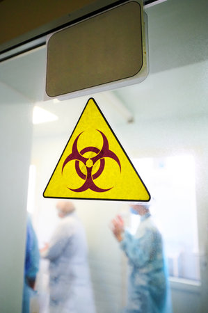 Biohazard warning sign on transparent laboratory doorの写真素材