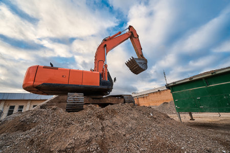 Excavator digs Sand and gravel with bucket at construction siteの写真素材