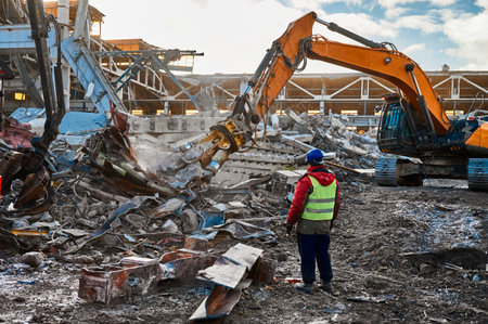 Excavator destroyer removes debris under worker controlの写真素材