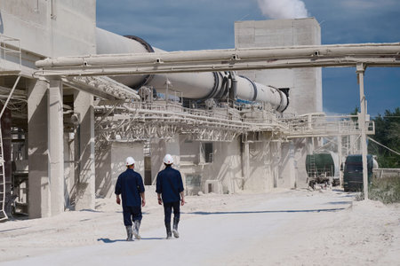 Workers in uniforms walk across yard of huge lime plantの写真素材