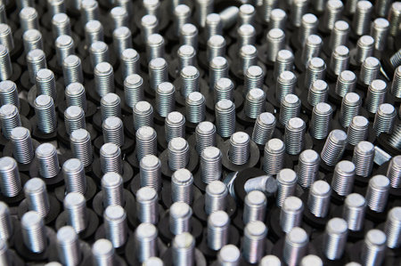 Metal screws in container on workbench at car service