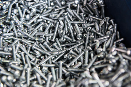 Metal screws in container on workbench at car serviceの写真素材