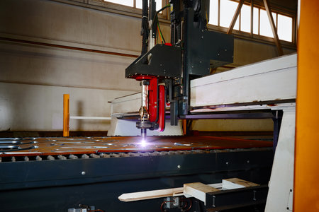 Plasma cutting of metal plate with flying sparks in workshopの写真素材