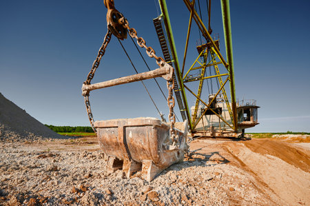 Bucket of old walking excavator digging calx in quarry
