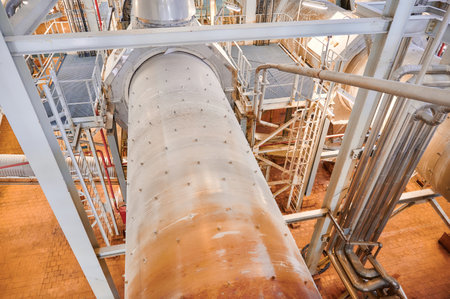An overview of the interior of a chemical plant featuring extensive pipelines and a conveyor system...