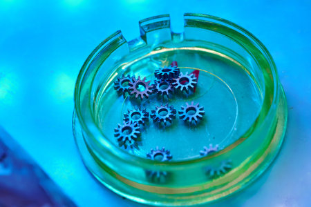 Intricate clockwork gears resting in a vibrant glass dish, showcasing the artistry of mechanical...