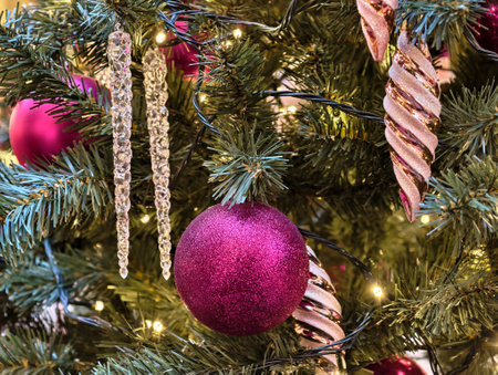 Elegant Christmas tree adorned with vibrant ornaments and shimmering icicles for a festive...