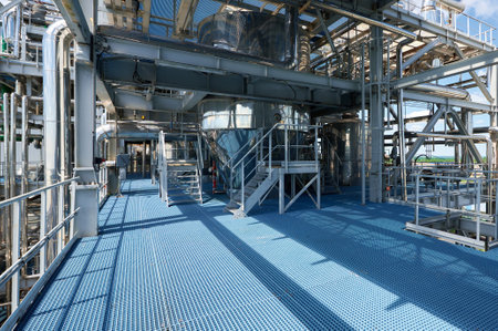 Industrial chemical plant with complex pipelines and structures under clear skies during daytime...