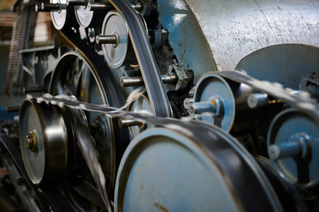 Exploring the intricate workings of a vintage carding machine in a textile workshopの写真素材