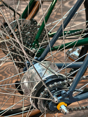 Exploring the intricate design and mechanics of a bicycle wheel in vibrant colors and textures set against a rustic wooden backdropの写真素材