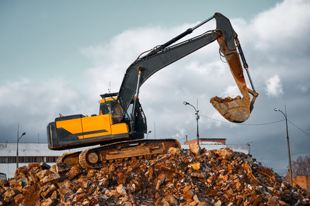 Building excavator with bucket stands on concrete waste
