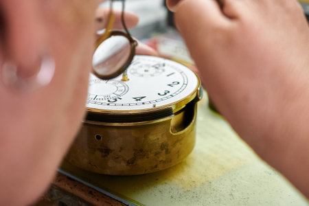 An expert artisan meticulously repairs a delicate chronometer in a softly lit workshop filled with...