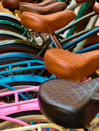Bicycles with colorful frames and unique leather seats gathered together in a vibrant indoor space showcasing creativity and designの写真素材