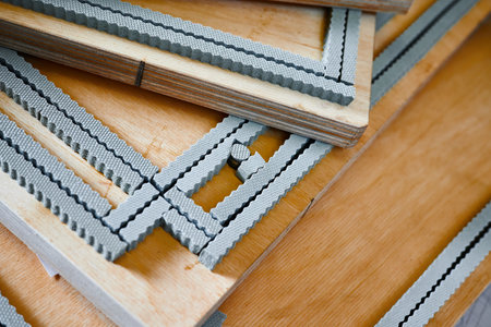 Creative process of die cutting for cardboard box manufacturing in a workshop setting during daytimeの写真素材