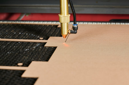 Precision laser cutting of cardboard sheets in an industrial box manufacturing plant during daytime...