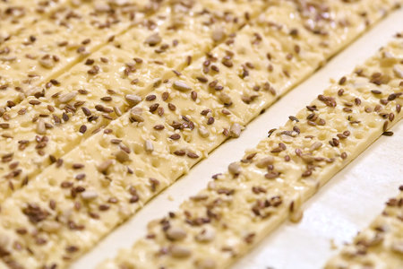 Cracker dough strips are being processed on the conveyor belt in a busy production facility