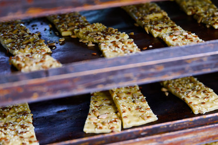 Cracker dough strips prepared and ready for baking in oven trays at a busy kitchen