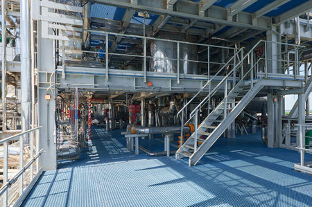 Industrial chemical plant featuring extensive pipelines and processing units during daylight hours
