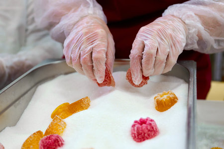 Hand-sugaring marmalade candy in artisanal confectionery workshop for private production