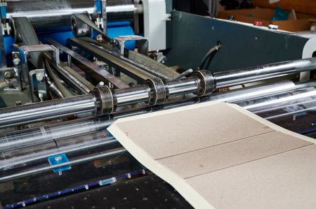 Advanced machine efficiently folds cardboard flaps for seamless packaging process in a busy production environmentの写真素材