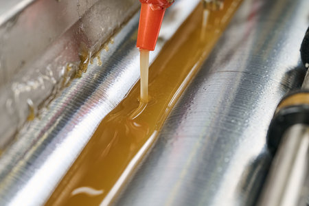 Efficient glue application process in action with a precision glue-spreading machine at a manufacturing facilityの写真素材