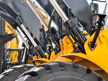Heavy machinery working at a construction site with hydraulic systems displayed clearly during daytimeの写真素材