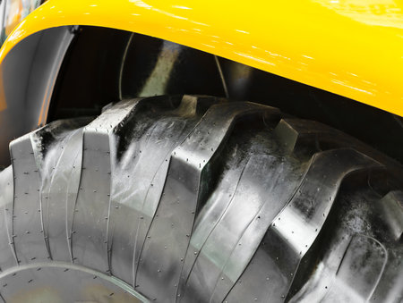 Heavy construction equipment wheel showcasing detailed tread pattern at a construction site during daylightの写真素材